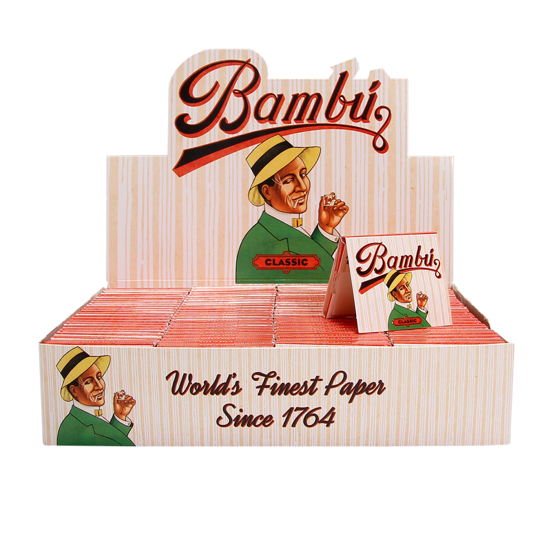 Display stand with Bambu Bambú Classic paper packs and a promotional sign featuring a vintage-style illustration of a man in a hat, holding a paper.