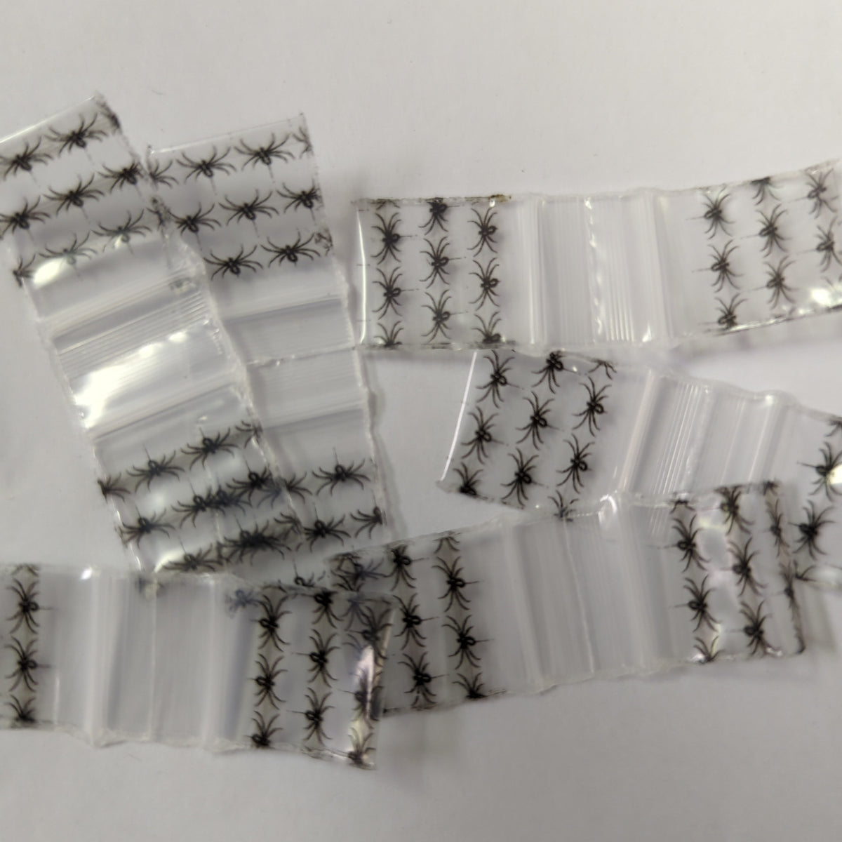 Black spider design resealable bags from Original Apple Bags, 5/8 inch by 5/8 inch, ideal for storing small items.