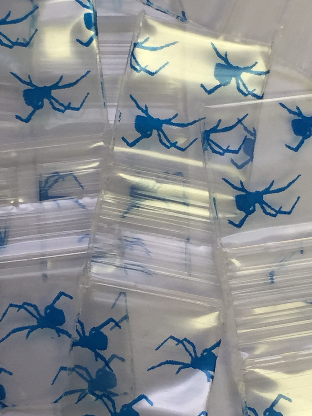 Black 1/2" x 1/2" resealable bags with spider design from Original Apple Bags, ideal for packaging and storage.