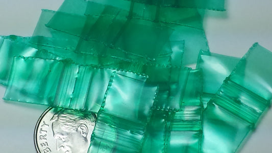Green 3/8 inch by 3/8 inch resealable Original Apple Bags, small transparent plastic bags for storage or packaging.