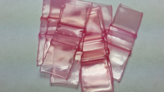 Pink resealable bags from Original Apple Bags, 1/2 inch by 1/2 inch, ideal for packaging small items.