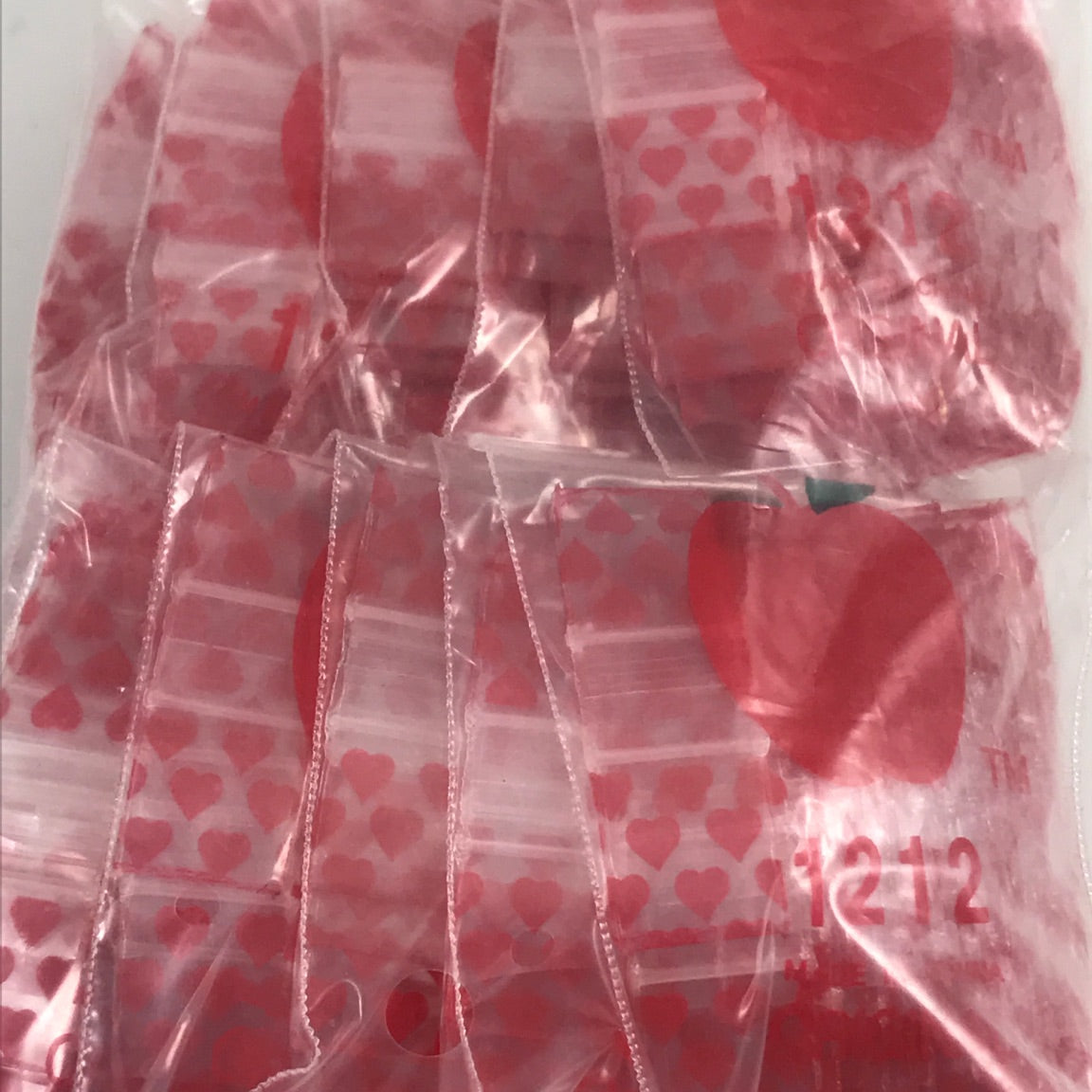 Resealable Original Apple Bags 1/2" x 1/2" with heart pattern, ideal for packaging small items or gifts.