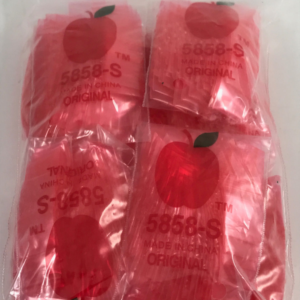 Red resealable bags from Original Apple Bags, 5/8 inch by 5/8 inch size, suitable for storing small items or snacks.