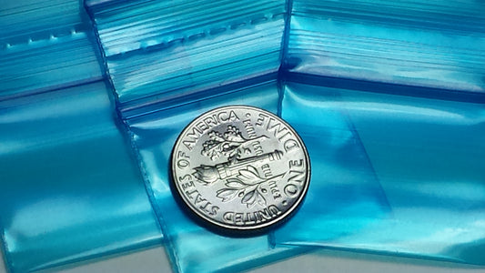 Blue Original Apple Bags resealable bags, 1.25" x 1", showing transparent plastic with blue print and resealable zipper closure.
