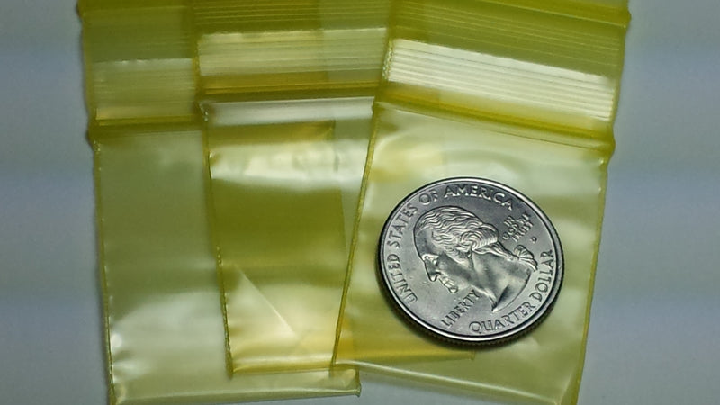 Original Apple Bags resealable yellow bags, 1.25" x 1.5", ideal for packaging small items and snacks.