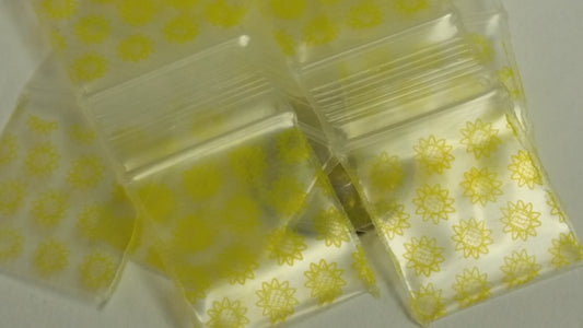 Original Apple Bags resealable 3/4" x 3/4" sunflower-themed bags for storing small items or treats.