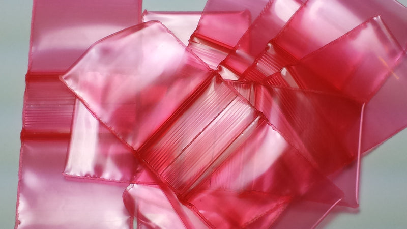 Red 1x1-inch resealable apple bags by Original Apple Bags, featuring transparent plastic for secure storage and display.