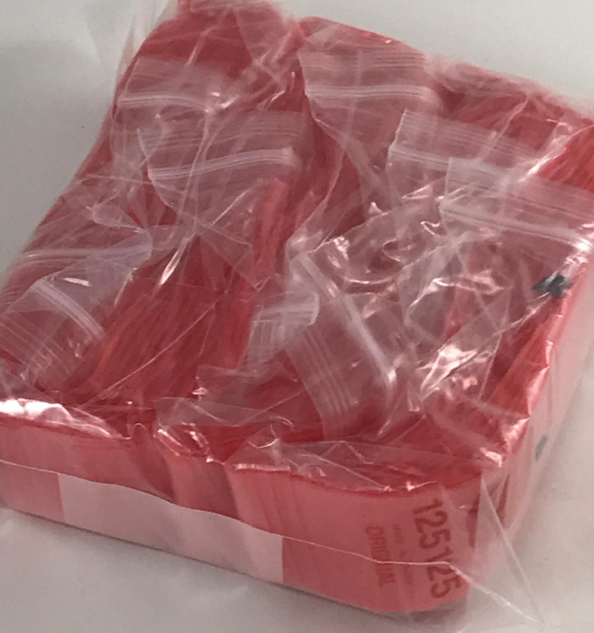 Red resealable Apple Bags, original brand, 1.25 inches by 1.25 inches, perfect for small item storage.