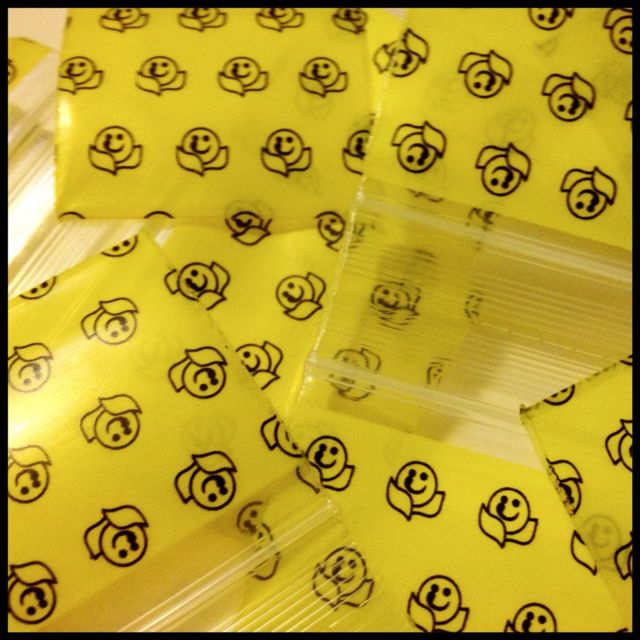 Resealable Original Apple Bags with happy face design, 1.5 x 1.5 inches, ideal for storing small items or snacks.