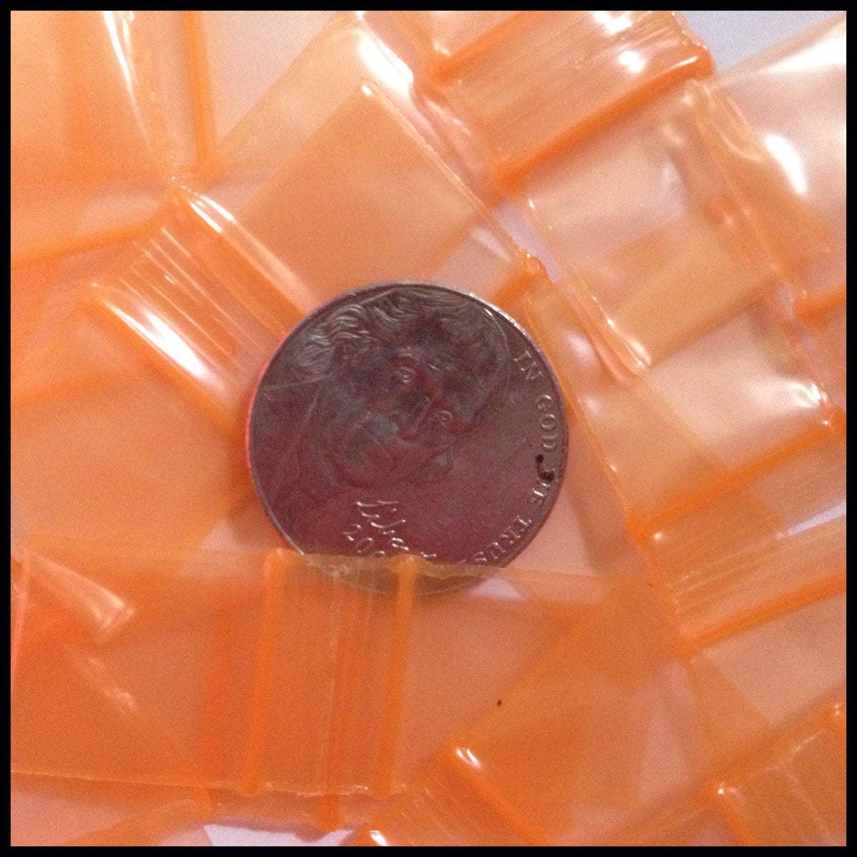 Resealable orange apple bags by Original Apple Bags, 5/8 inch by 5/8 inch, ideal for packaging small items.